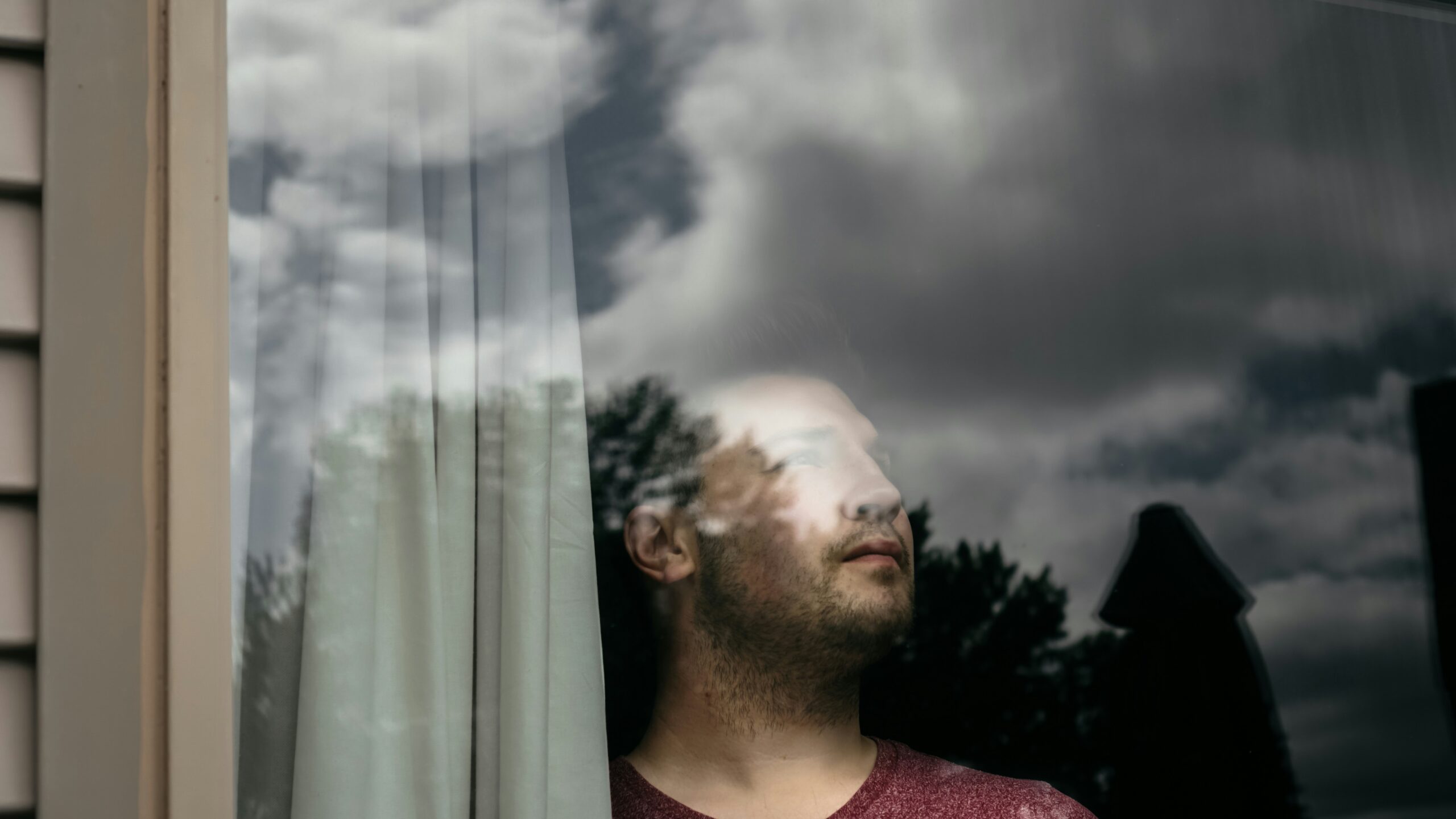 struggling after a near-death experience — figure looking out a window